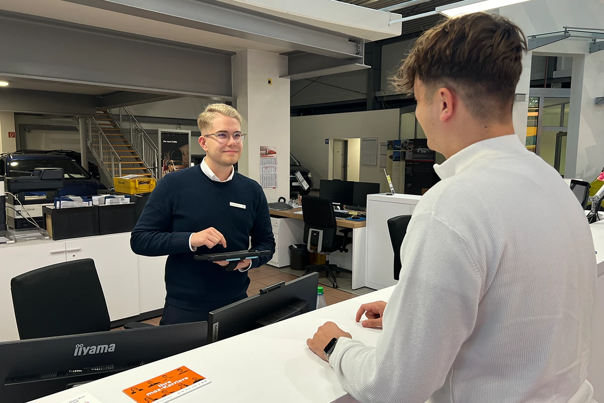 Mitarbeiter und Kunde im Innenbereich Volkswagen Zentrum Uelzen