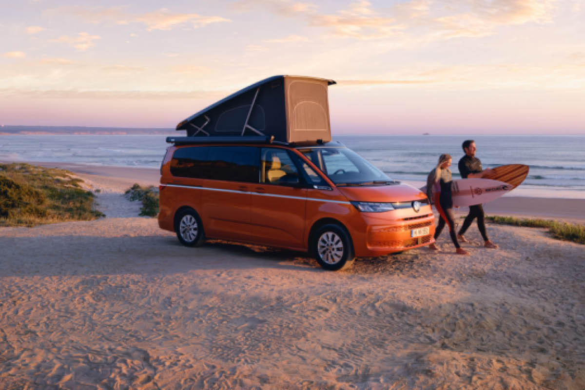 Oranger VW California mit 2 Surfer