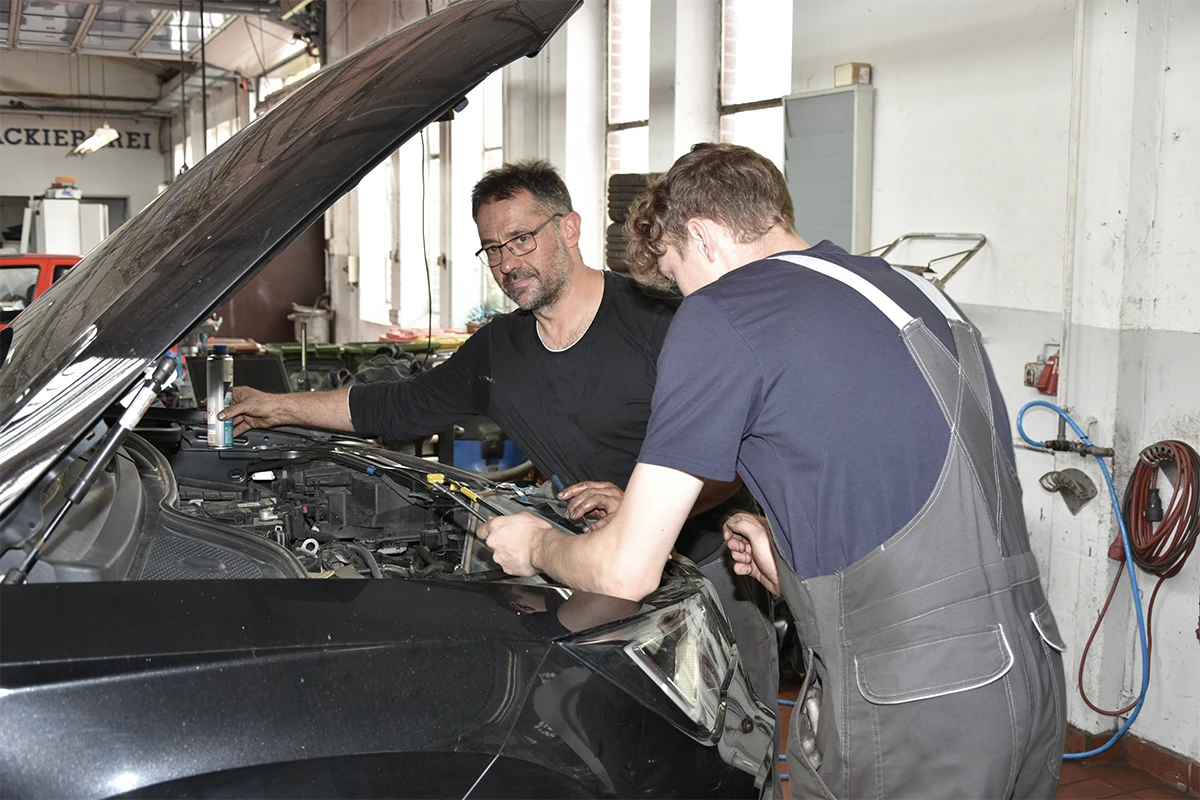 Mitarbeiter repariert ein Auto in der Werkstatt